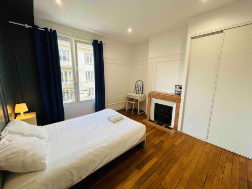 - une chambre avec un lit blanc et une cheminée dans l'établissement L'Etape Rémoise - Hypercentre, à Reims