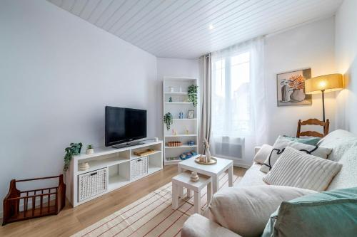 un salon avec un canapé et une télévision dans l'établissement LAtelier dEpinay Terracotta - Near Paris, à Épinay-sur-Seine