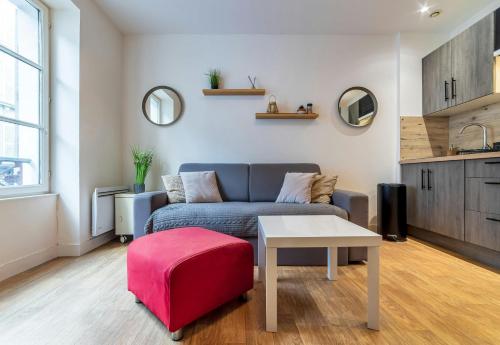 - un salon avec un canapé et un tabouret rouge dans l'établissement Le Central Bleau 1 - Hypercentre, à Fontainebleau