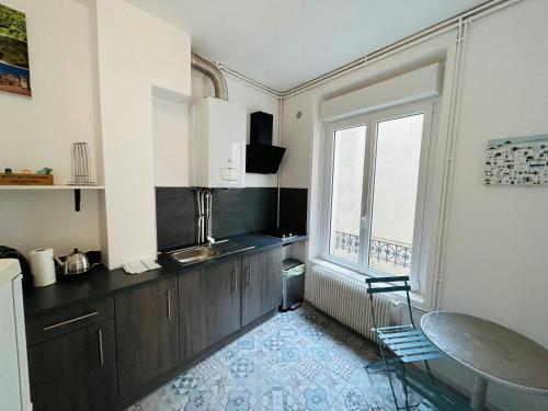 une cuisine avec un évier et une fenêtre dans l'établissement Le Millésime Coulvier Taittinger, à Reims