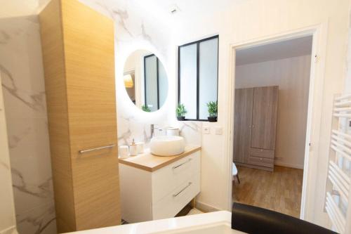 a bathroom with a sink and a mirror at Zenitude Balnéo Hypercentre Melun in Melun