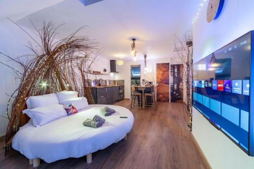 une chambre avec un grand lit blanc dans une pièce dans l'établissement Le Nichoir Cosy : Évasion Bien-être et Massage, à Vierzon