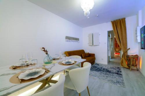a white dining room with a table and chairs at La Rêverie - Jacuzzi Lounge & Massage in Vierzon