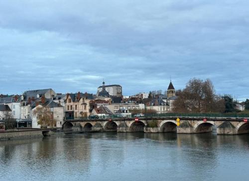 a bridge over a river with a city in the background at La Rêverie - Jacuzzi Lounge & Massage in Vierzon