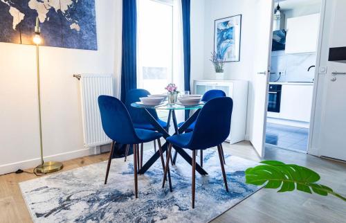 une salle à manger avec une table et des chaises bleues dans l'établissement L'Ecrin Bleu - Proche Paris, à Épinay-sur-Seine