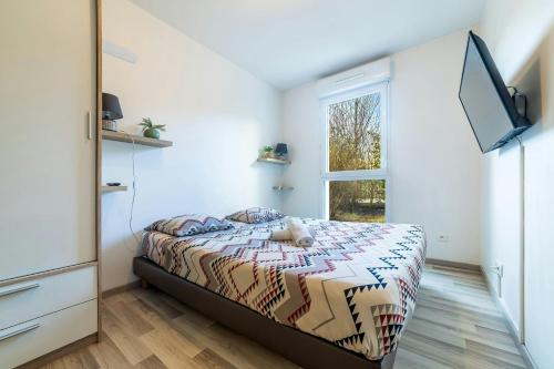 une chambre avec un lit, une télévision et une fenêtre dans l'établissement The Disneyland stay near to Disneyland, à Montévrain