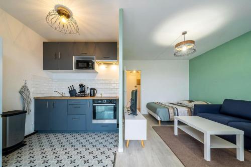 Il comprend une cuisine et un salon avec un canapé bleu. dans l'établissement Parisian Horizon near Paris, à Sartrouville