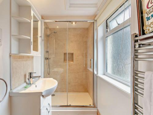 y baño con ducha, lavabo y cabina de ducha acristalada. en 1 bed in Barnstaple ELLCO, en Fremington