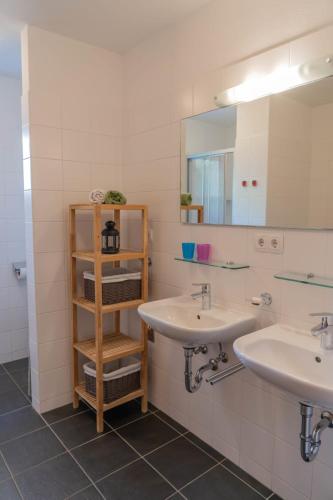 a bathroom with two sinks and a book shelf at Christina 1 by SMR Rauris Apartments - inc Spa and near Gondola in Rauris