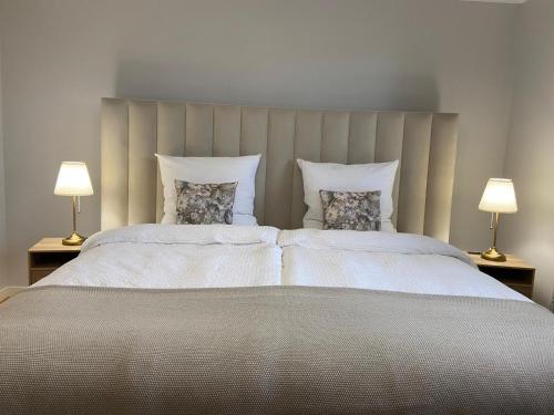 a large bed with two pillows and two lamps at Ferienwohnung - Ewigkeit in Minden