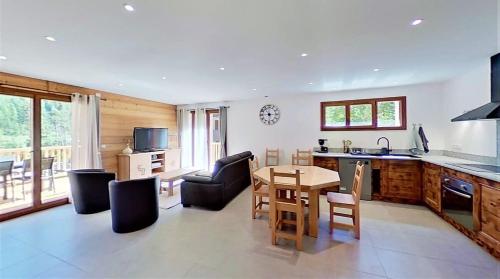 une cuisine et un salon avec une table et des chaises dans l'établissement CASA-Bruno family chalet Queyras 7p, à Aiguilles