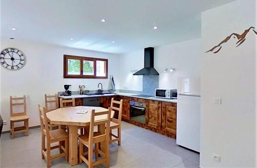 une cuisine avec une table et un réfrigérateur blanc dans l'établissement CASA-Bruno family chalet Queyras 7p, à Aiguilles