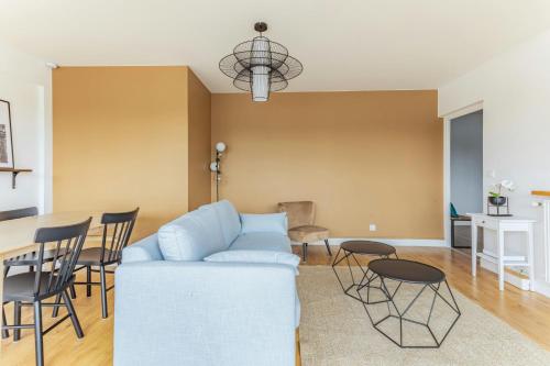 un salon avec un canapé et une table dans l'établissement Appart'Hôtel Luminous Vue Seine- Paris 15min, à Juvisy-sur-Orge