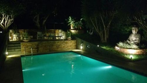 a swimming pool in a yard at night at 3 Palmeiras Guest Lounge in Miguel Pereira
