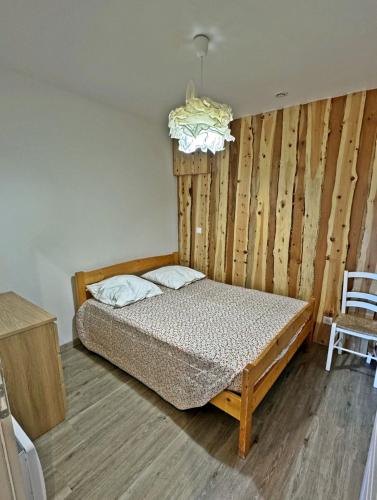 une chambre avec un lit et un mur en bois dans l'établissement Chez-Cecile Risoul piscine et sauna pied de pistes, à Risoul