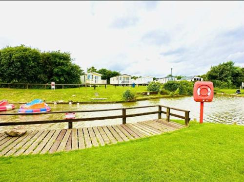 a wooden dock next to a body of water at 14 Atlas Ruby Cherry tree in Gristhorpe