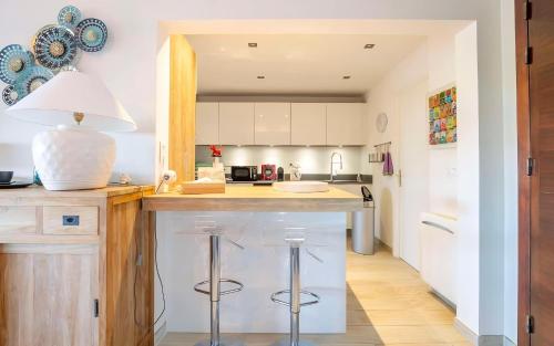 - une cuisine avec un comptoir et des tabourets dans l'établissement CASA-Villa des Oiseaux, aux Issambres