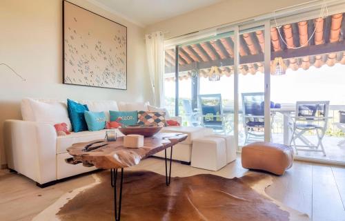 un salon avec un canapé blanc et une table dans l'établissement CASA-Villa des Oiseaux, aux Issambres