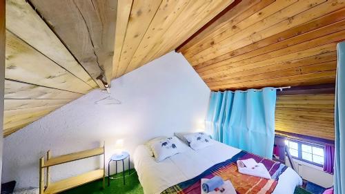 a bedroom with a bed and a wooden ceiling at CASA-La Lorraine lovely studio in a chalet St-Véran 4p in La Chalp-Sainte-Agathe