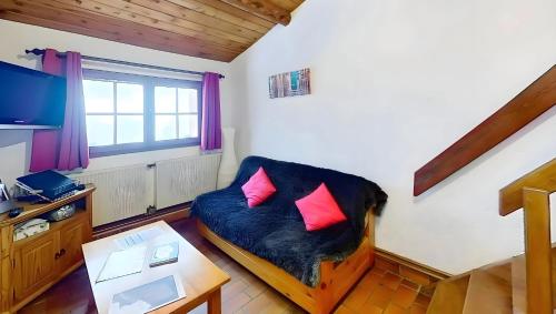 a living room with a couch with two pink pillows at CASA-La Lorraine lovely studio in a chalet St-Véran 4p in La Chalp-Sainte-Agathe