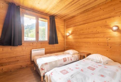 a bedroom with two beds in a wooden cabin at CASA-Chalet du Parc Cosy apartment in Tignes with garden in Tignes
