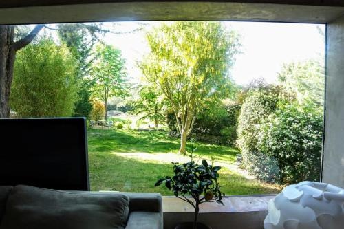 - un salon avec une grande fenêtre donnant sur une cour dans l'établissement CASA-Villa Amanda, à Mimet