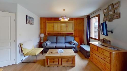 un salon avec un canapé bleu et une table dans l'établissement CASA-Amélie terrasse vue parking, à Vars