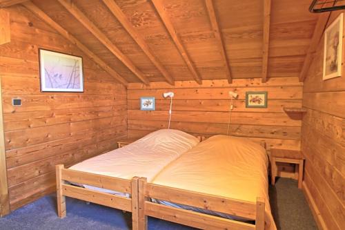 a bed in a wooden room in a cabin at CASA Les Heureux Magnifique CHALET 6 chambres à RISOUL in Risoul