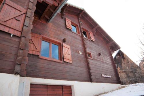 a wooden house with windows on the side of it at CASA Les Heureux Magnifique CHALET 6 chambres à RISOUL in Risoul