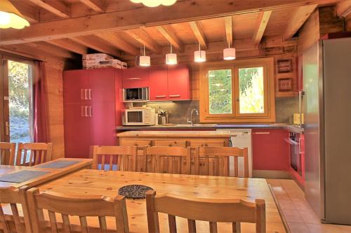 a kitchen with a wooden table and a dining room at CASA Les Heureux Magnifique CHALET 6 chambres à RISOUL in Risoul