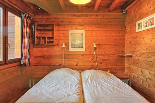 a bedroom with a bed in a wooden wall at CASA Les Heureux Magnifique CHALET 6 chambres à RISOUL in Risoul