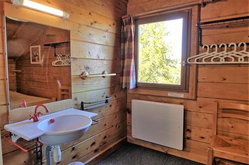 a bathroom with a sink and a mirror and a window at CASA Les Heureux Magnifique CHALET 6 chambres à RISOUL in Risoul