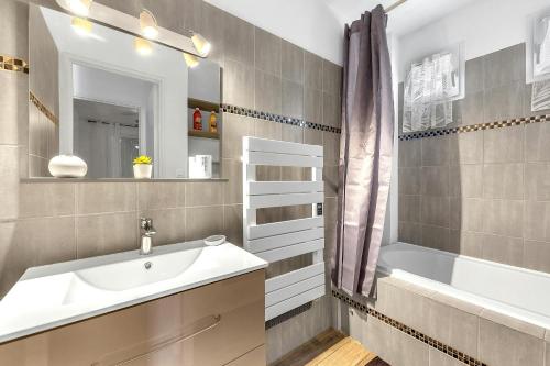une salle de bain avec un lavabo, une baignoire et un miroir dans l'établissement Le Grand Fournas comfort near shops, à Draguignan