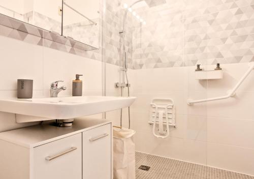 a white bathroom with a sink and a shower at Appartement Cosy à Vence avec Piscine & Parking in Vence