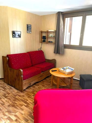 un salon avec un canapé rouge et une table dans l'établissement CASA-Bois de Pisan at the foot of the slopes, à Molines-en-Queyras