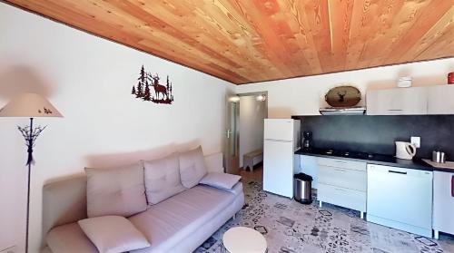 a living room with a couch and a kitchen at CASA-La Lobio foot of the slopes breathtaking views 4p in Saint-Véran