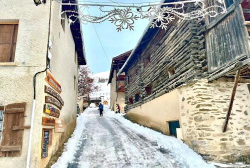 a person walking down a snow covered street at CASA-La Lobio foot of the slopes breathtaking views 4p in Saint-Véran
