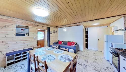 una sala da pranzo con un tavolo e un divano di Casa-La Fuste centre Saint-Véran ski au pied a Saint-Véran