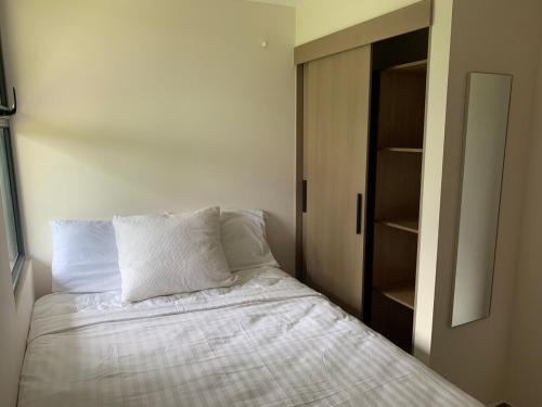 a bedroom with a bed with white sheets and a closet at Apartamento en Cipreses San Ignacio, Tegucigalpa in Tegucigalpa