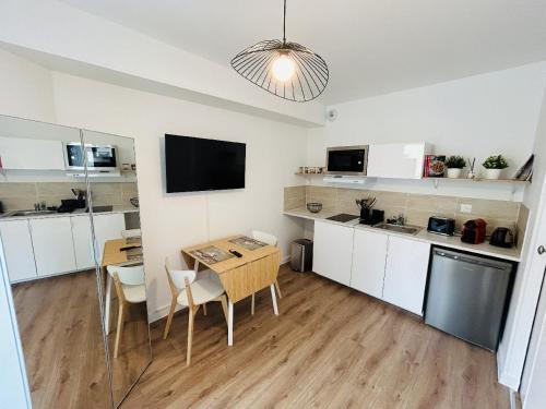 une cuisine avec une petite table et une salle à manger dans l'établissement Le Charmant Créneau - Basilique, à Reims