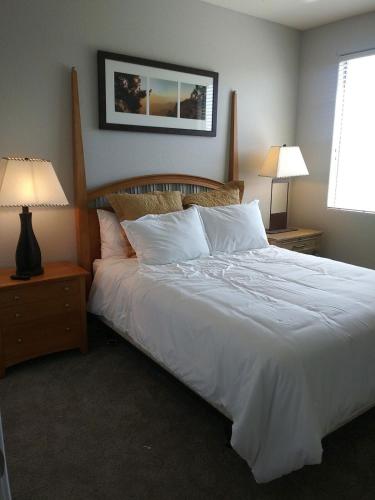 a bedroom with a bed with white sheets and pillows at VILLA Verde Surprise Stadium - Resort Living in Surprise