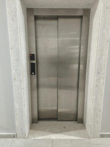 a large metal elevator door in a building at Tůma Family Apartment in Golem