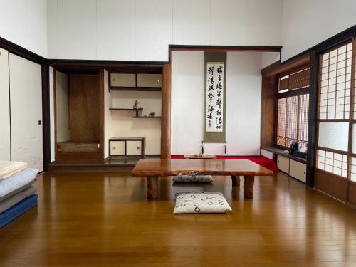 a living room with a table and a room with windows at Kaen - Vacation STAY 19038 in Aso