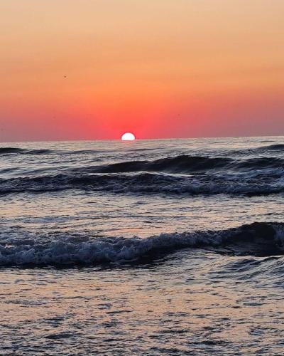a sunset over the ocean with the sun setting at Alexander Studio White Titanic in Mamaia Sat/Năvodari