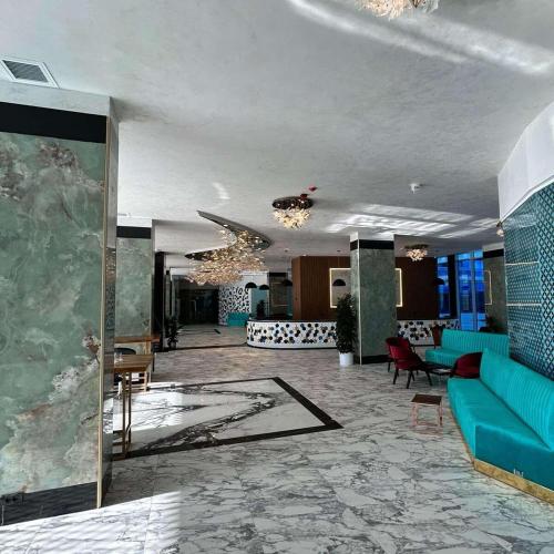 a lobby with a blue couch and chairs in a building at Alexander Studio White Titanic in Mamaia Sat/Năvodari