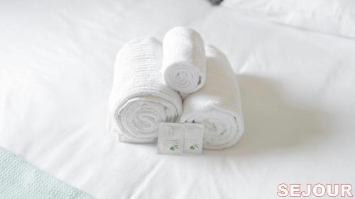 a pile of towels sitting on a bed at 5 minutes du Zénith - Studio Chic in Pantin