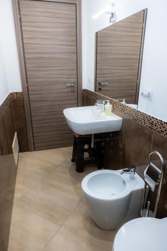 a bathroom with a sink and a toilet and a mirror at La dimora dei ricci in Santo Stefano di Camastra