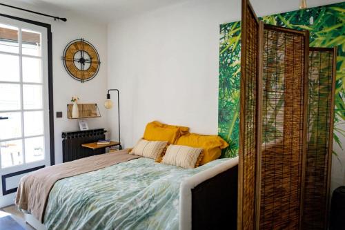 une chambre avec un lit et une horloge au mur dans l'établissement LeCosy - Studio 2 Personnes, à Gréoux-les-Bains