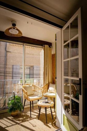 Cette chambre dispose d'un balcon avec une chaise et une table. dans l'établissement LeCosy - Studio 2 Personnes, à Gréoux-les-Bains