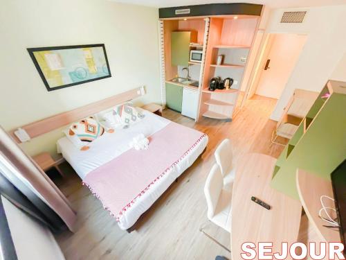 a small room with a bed and a table at 5 minutes du Zénith - Studio Chic in Pantin